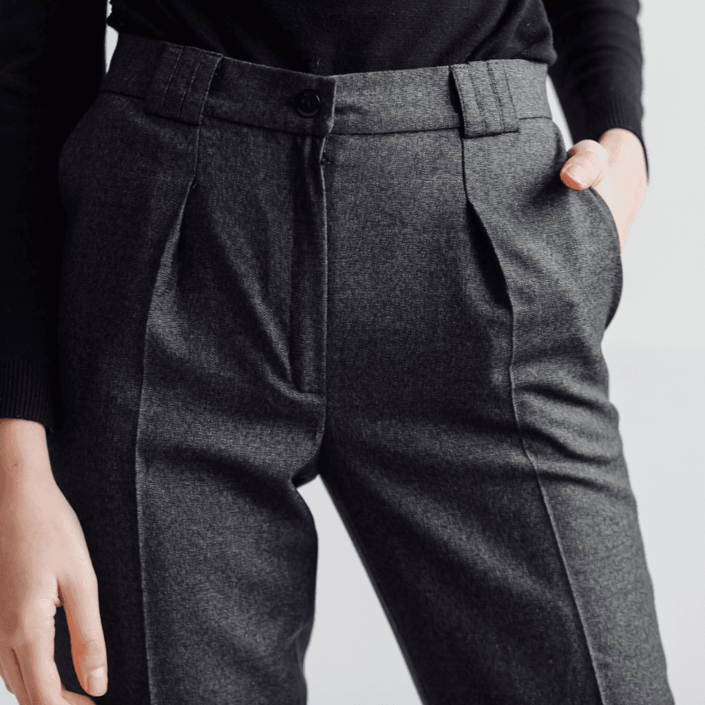 Close-up of tailored grey wool trousers with a pressed crease and slant pocket