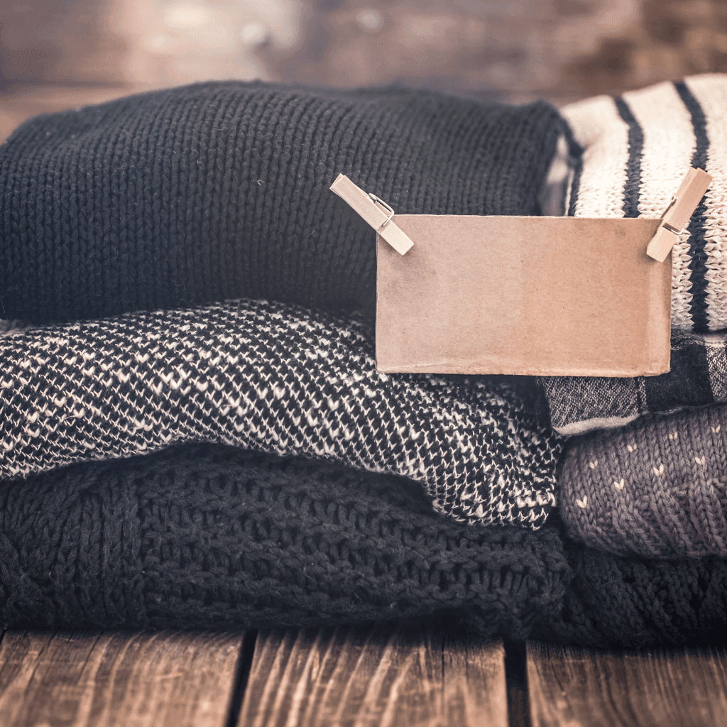 Folded knitted custom t-shirts with brand label and wooden clothespins