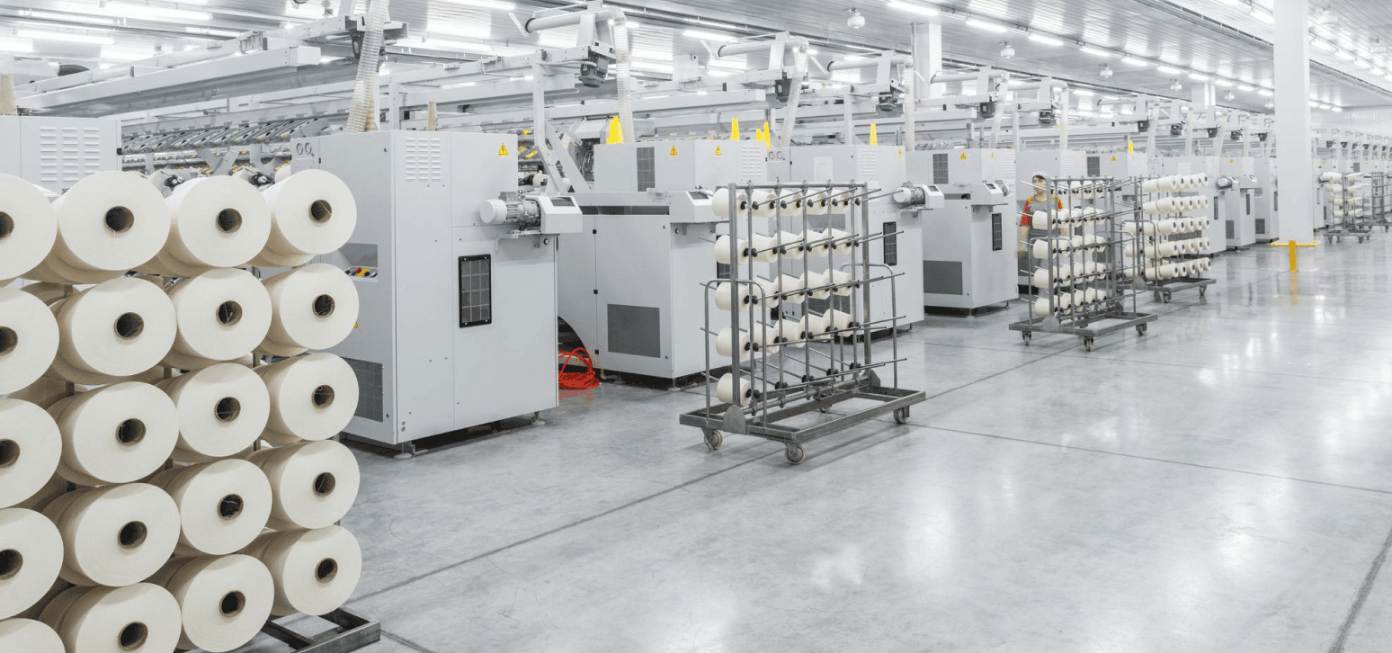 Nevear advanced apparel manufacturing facility with automated textile machinery and yarn spools